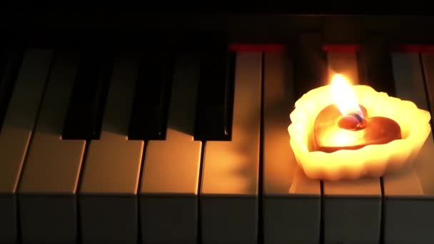 Herzförmige Kerze auf Klavier — Stockvideo