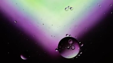 Soyut Renkli Gıda Yağı Damlaları Kabarcıklar ve küreler Su yüzeyinde, makro Videografi
