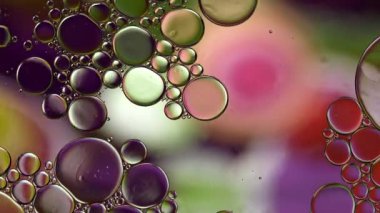 Soyut Renkli Gıda Yağı Damlaları Kabarcıklar ve küreler Su yüzeyinde, makro Videografi