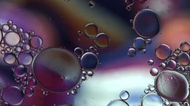 Soyut Renkli Gıda Yağı Damlaları Kabarcıklar ve küreler Su yüzeyinde, makro Videografi