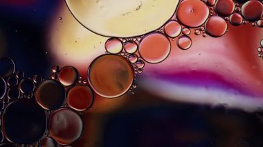 Soyut Renkli Gıda Yağı Damlaları Kabarcıklar ve küreler Su yüzeyinde, makro Videografi