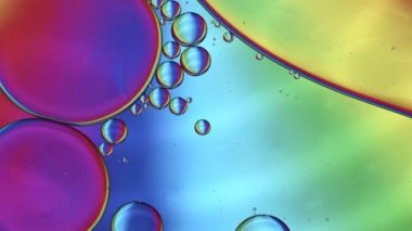Soyut Renkli Gıda Yağı Damlaları Kabarcıklar ve küreler Su yüzeyinde, makro Videografi