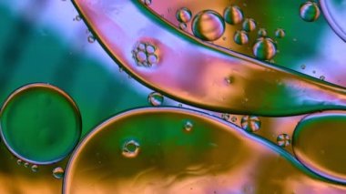 Soyut Renkli Gıda Yağı Damlaları Kabarcıklar ve küreler Su yüzeyinde, makro Videografi