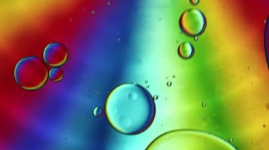Soyut Renkli Gıda Yağı Damlaları Kabarcıklar ve küreler Su yüzeyinde, makro Videografi