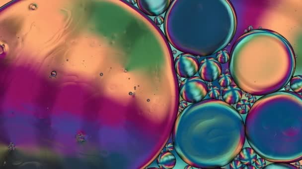 アブストラクトカラフルな食品油滴泡と球が水面に流れるマクロな映像 — ストック動画