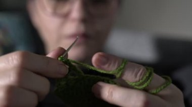 Renkli yün ve iğne toplarıyla Genç Kadın Örgü örüyor
