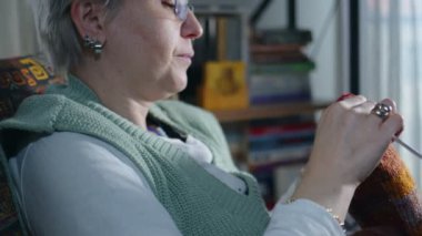 Renkli yün ve iğne toplarıyla Genç Kadın Örgü örüyor