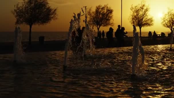 Wasserfontäne Und Menschensilhouette Sonnenuntergang — Stockvideo