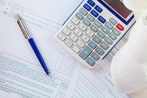Formulario de impuestos, calculadora y pluma —  Fotos de Stock