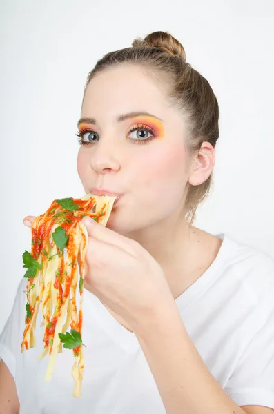 Bella donna con un grande appetito aiutando ogni mano a mangiare un lungo, delizioso spaghetti . — Foto Stock