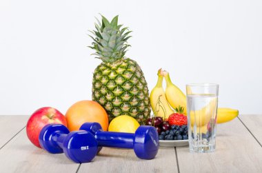 muz, elma, ananas, limon, yaban mersini, çilek, kiraz ve bir bardak su ve ağırlıkları