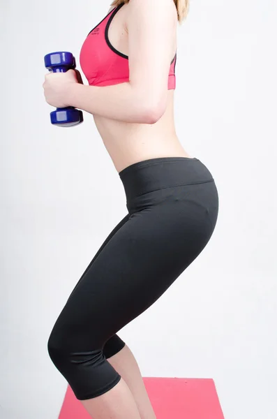 Silueta de una mujer sosteniendo pesas, realizando ejercicios de fuerza en ropa deportiva —  Fotos de Stock