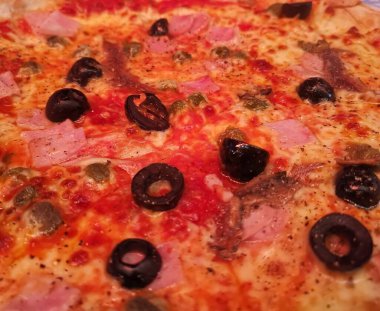 Siyah zeytin ve domatesli pizzanın tam kare görüntüsü