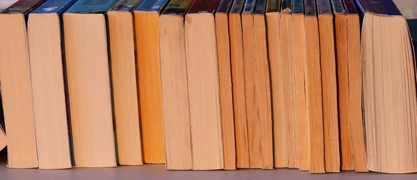 Papírhátú könyvek sora a felületen, fénymásoló felülettel — Stock Fotó