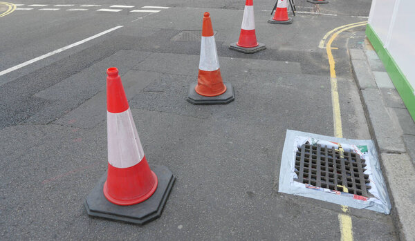 View of English street with traffic cones, yellow and white line markings