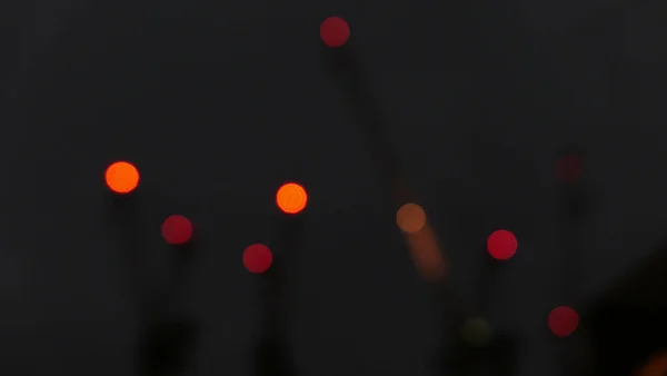 Luces rojas desenfocadas en grúas de construcción contra el cielo oscuro nocturno —  Fotos de Stock