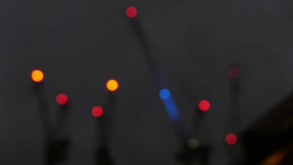 Luces rojas y azules desenfocadas en grúas de construcción contra el cielo oscuro nocturno —  Fotos de Stock