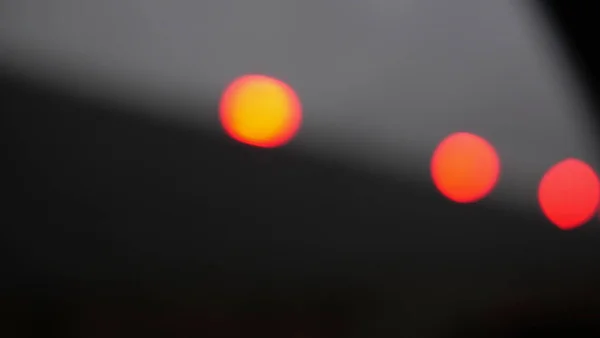 Tres luces rojas anaranjadas desenfocadas contra fondo gris con espacio para copiar —  Fotos de Stock