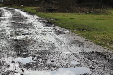 Islak bir günde, kışın İngiliz tarım arazileri araç lastiği izlerini gösteriyor