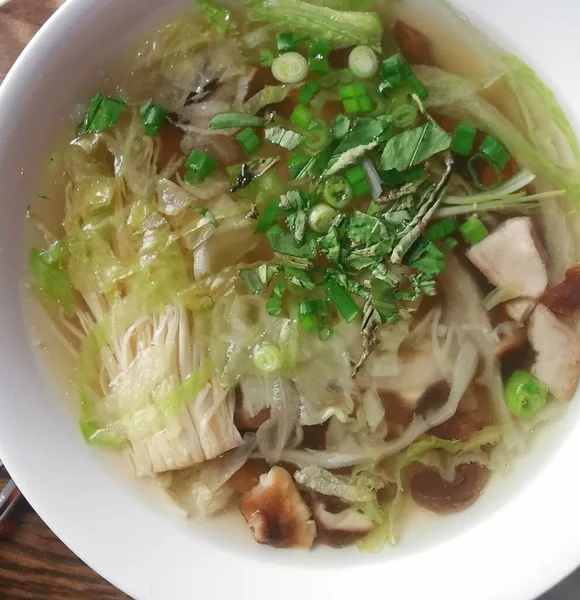 Вкусное блюдо из тайского грибного супа, украшенное луком — стоковое фото