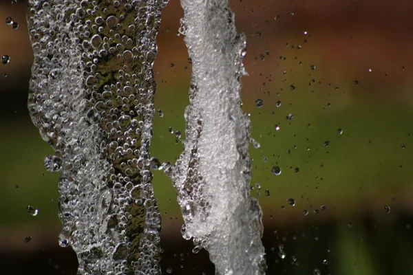 Close up of water fountain in garden setting with blurred background — Zdjęcie stockowe