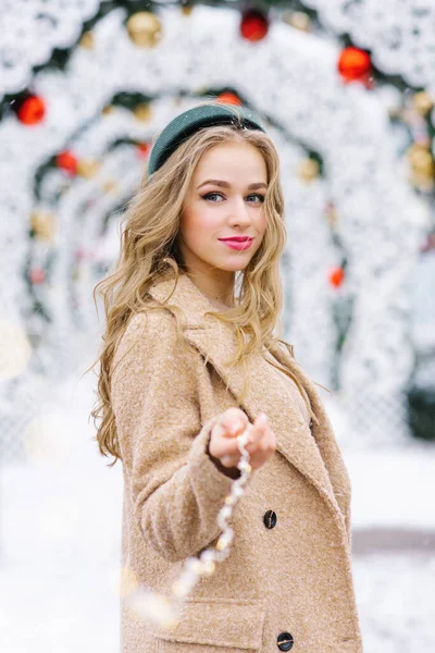 Милая Молодая Женщина Держит Руке Гирлянду Фоне Рождественского Базара — стоковое фото
