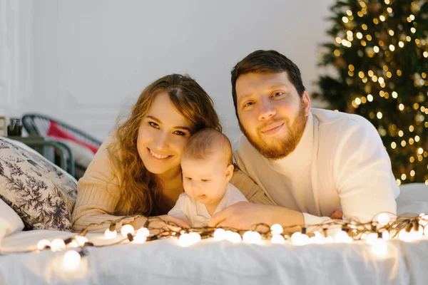 Mutlu Anne Baba Noel Işıklarının Arkasında Bebeklerinin Yanında Yatıyorlar — Stok fotoğraf