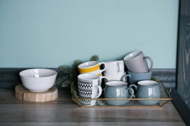 Mutfakta mavi ve gri tonlarda çeşitli bardak ve bardaklar var.