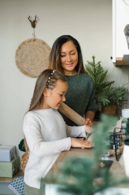 Annem ve altı yaşındaki kızı mutfakta zencefilli Noel kurabiyeleri yapıyor.