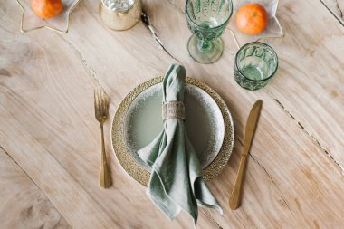 Noel / Yeni Yıl kompozisyonları. Mandalina, tabak, bıçak, çatal ve bardaklarla süslenmiş Noel ve Şükran Günü sofrası. Düz yerde, üst tarafta. Kış tatili kavramı.