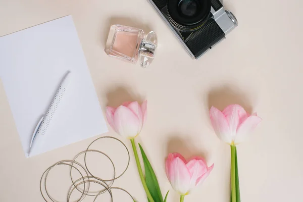 ヴィンテージカメラ ピンクの春のチューリップ ノート 紙とペンの空白のシート 香水やベージュの背景に女性のブレスレット ブロガーのための春の概念 母の日またはバレンタインカード — ストック写真