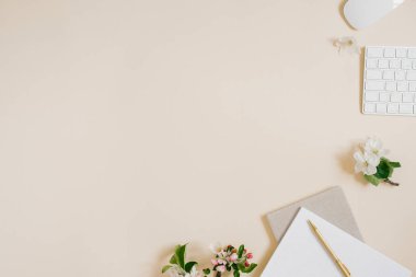 Ofis masası Not defteri veya planlamacı, kalem, bilgisayar ve narin elma çiçekleri. Yukarıdan bak. Düz yatıyordu. Merkez ofis çalışma alanı. Boşluğu kopyala