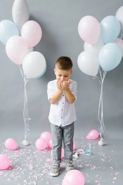Liten Pojke Barn Blåser Konfetti Grå Bakgrund Med Färgglada Ballonger — Stockfoto