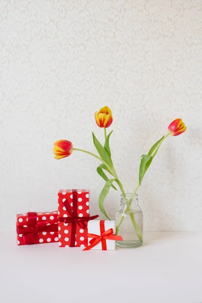 美しいチューリップとギフトボックスの花束をテーブルの上に花瓶 バレンタインデーのグリーティングカード3月8日母の日 — ストック写真