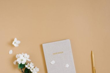 Ofis masası Not defteri veya planlamacı, kalem ve narin elma çiçekleri. Yukarıdan bak. Düz yatıyordu. Merkez ofis çalışma alanı.