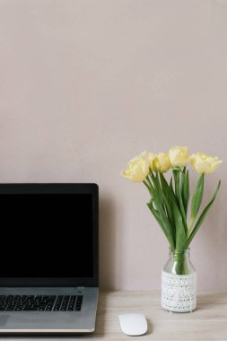 Teknoloji ve uzaktan çalışma konsepti. Taze çiçekleri olan güzel metin yazarları işyerinin ön manzarası