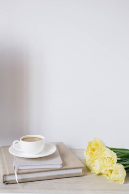 Güzel sarı laleler, not defterleri ve bir serbest veya blog yazarının masasında bir fincan kahvenin yaratıcı kompozisyonu