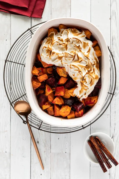 Eine Auflaufform gefüllt mit Merengue garniert gebackene Süßkartoffeln und Rüben. — Stockfoto