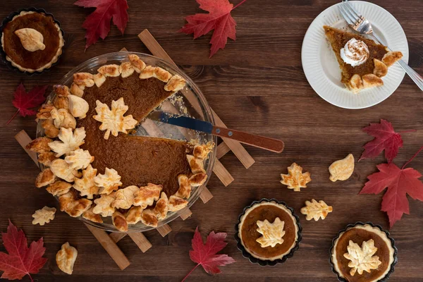 Top down view of a fresh homemade pumpkin pie with one slice on a plate. — Stock Photo, Image