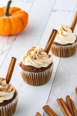 Tahta bir masanın üzerinde üç balkabağı baharatlı kek..