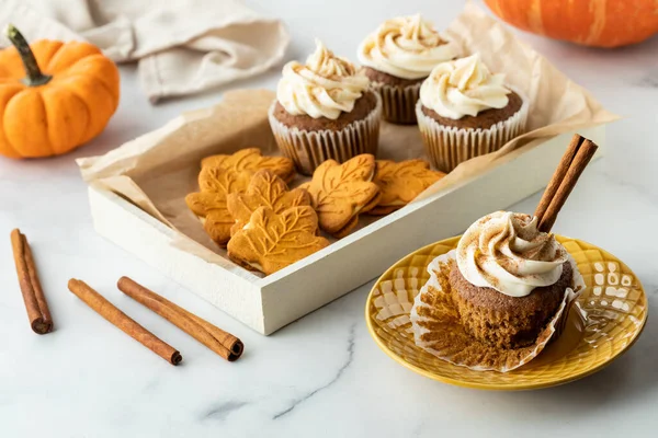 Una bandeja de galletas de especias de calabaza y cupcakes y un cupcake en un plato. — Foto de Stock
