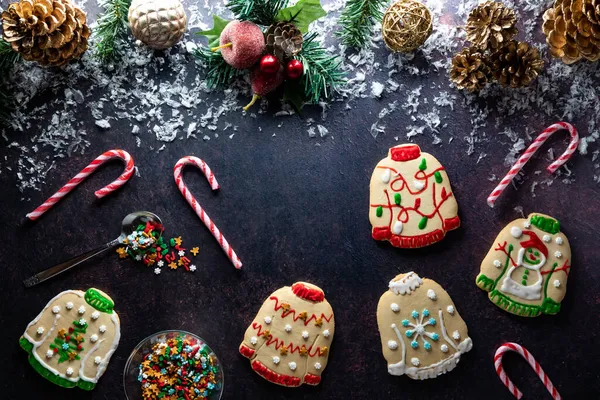 Ugly Christmas sweater cookies scattered about with Christmas decorations above. — Stock Photo, Image