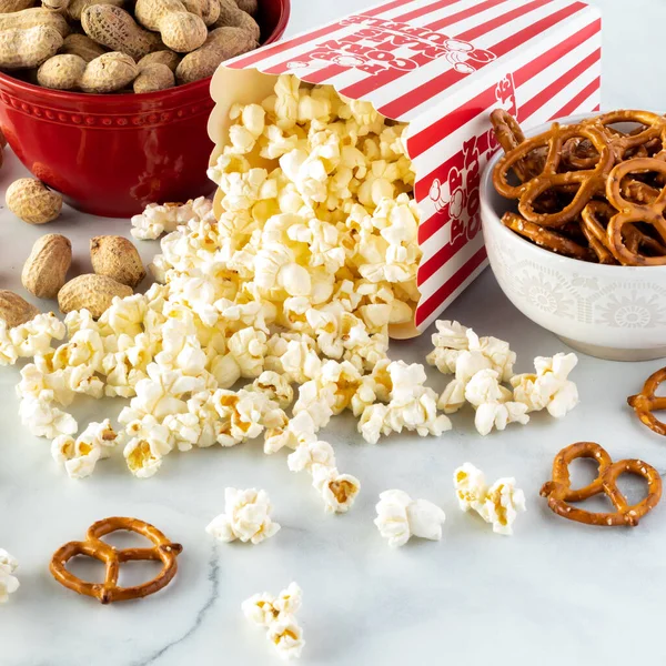 Großaufnahme von Behältern mit Erdnüssen, Popcorn und Brezeln zum Naschen. — Stockfoto