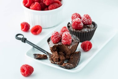 Çikolatalı ahududu bardakları bir kaşık dolusu, tabakta dinleniyor.