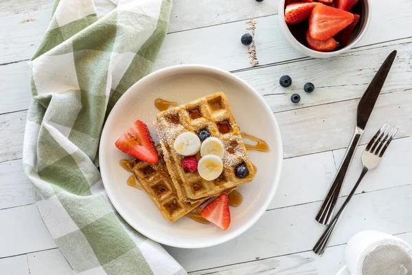Top down view of a plate of whole grain waffles topped with sliced fruit. — Stock Photo, Image