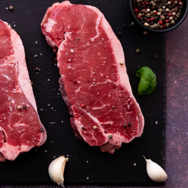 Top down close up view of a raw striploin steak with seasoning. — Fotografia de Stock