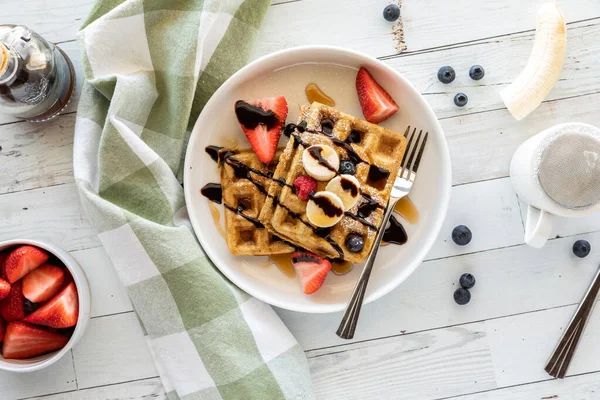 Homemade whole grain waffles topped with fruit and chocolate drizzle. — Stock Photo, Image