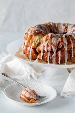 Apple cinnamon pull apart cake with a piece on a plate in front.