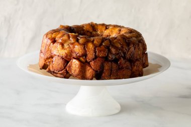 Apple cinnamon pull apart cake on a pedestal stand, against a light background.