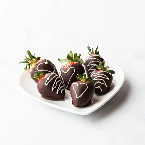チョコレートはイチゴをカバーし、正面中央のものに焦点を当てています. — ストック写真
